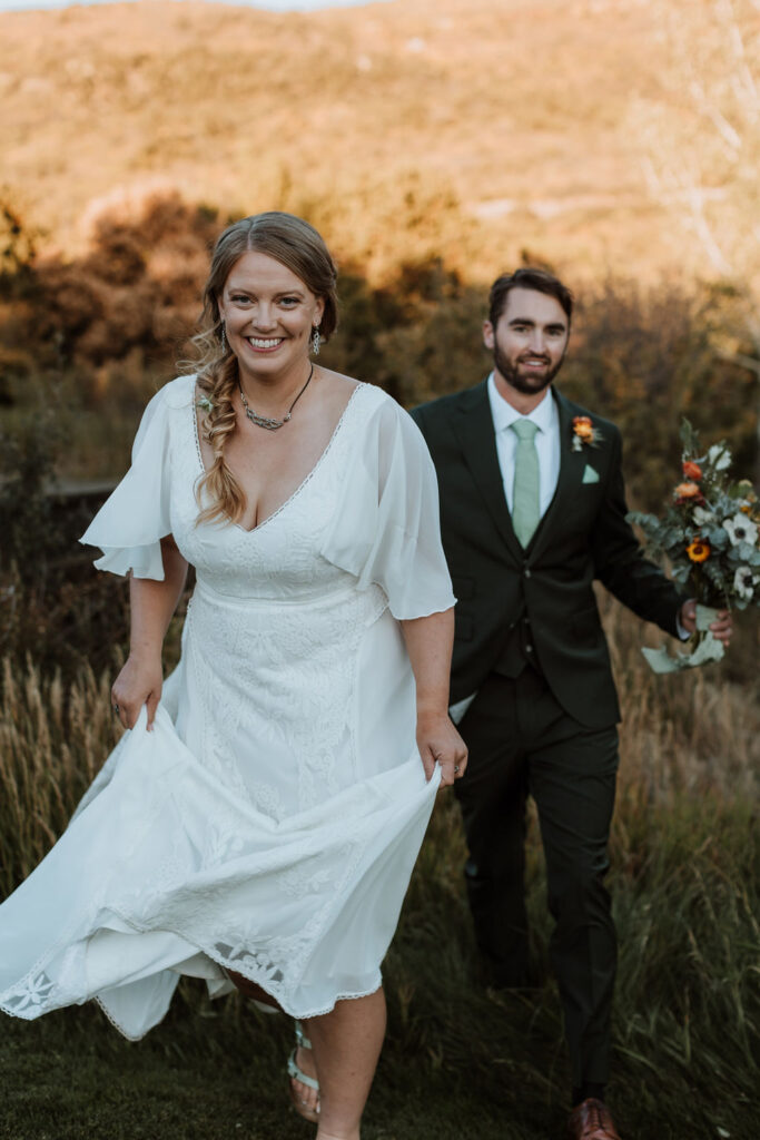 couple walks through sunset field together