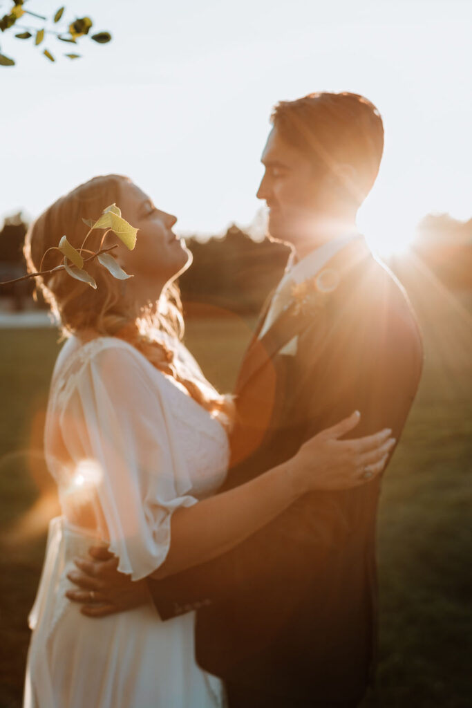 couple embraces in field at sunset outdoor elopement