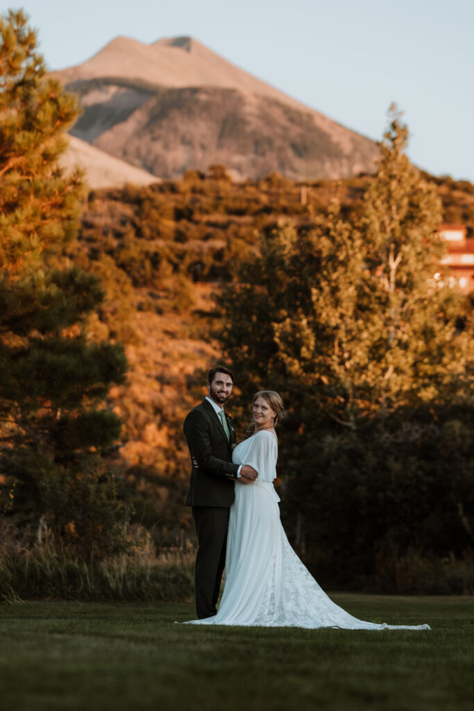 couple embraces under mountains at Whispering Oaks Ranch wedding