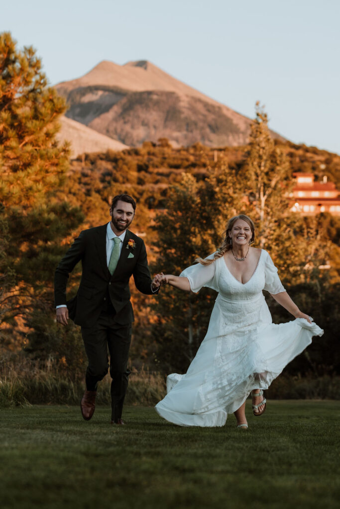 couple runs through field at Whispering Oaks Ranch wedding