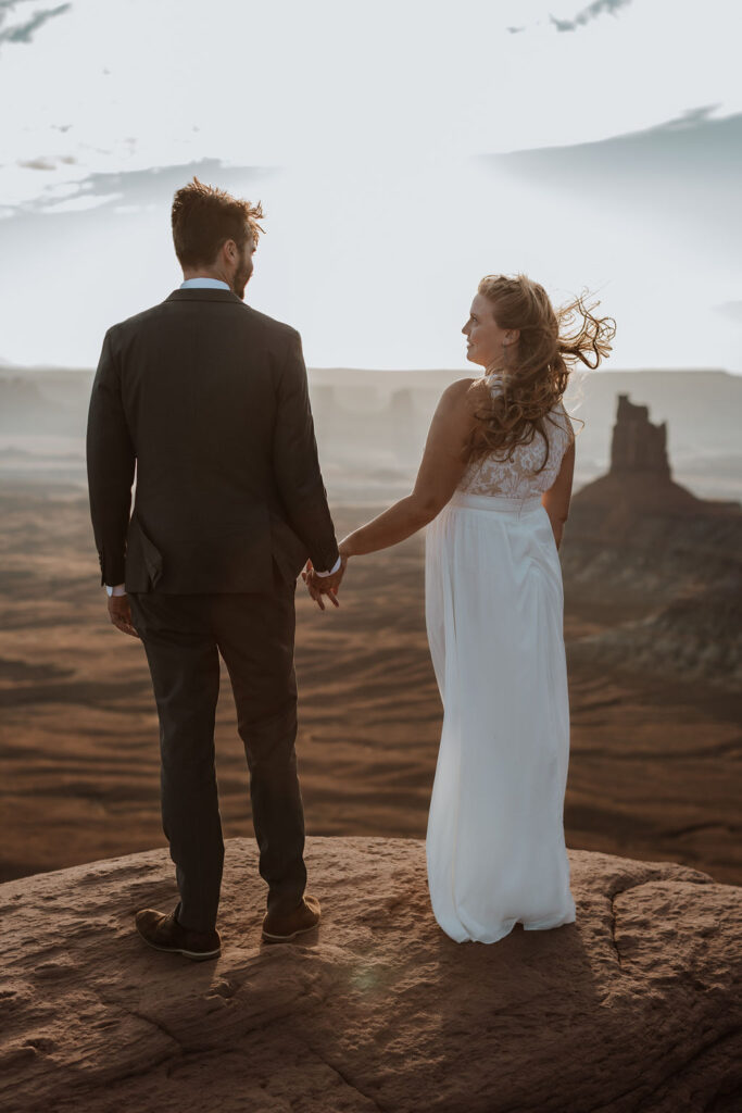 couple stands on overlook at Canyonlands National Park elopement