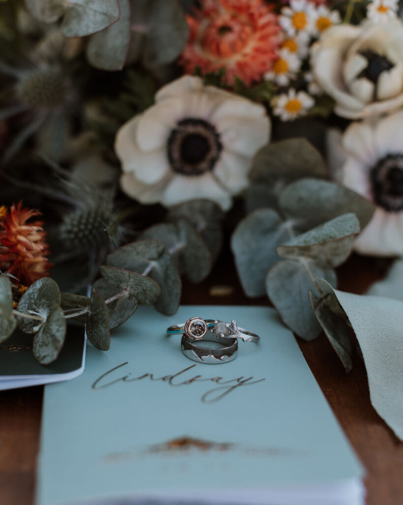 wedding bouquet and rings on vow books