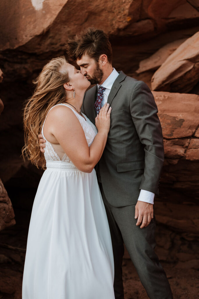 couple kisses at windy Canyonlands National Park elopement