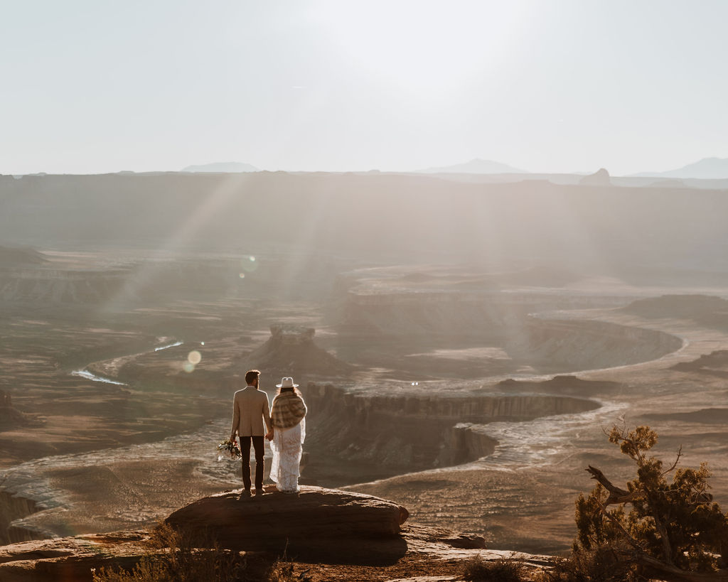 couple stands on cliff edge at Canyonlands elopement