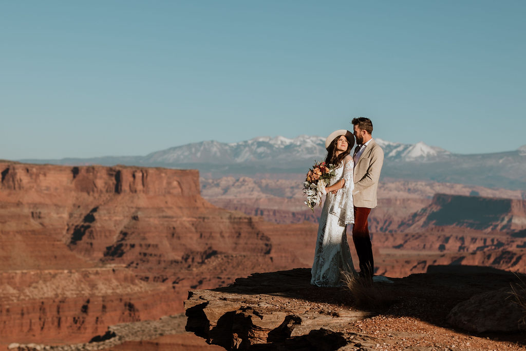 couple stands on cliff edge at Canyonlands elopement