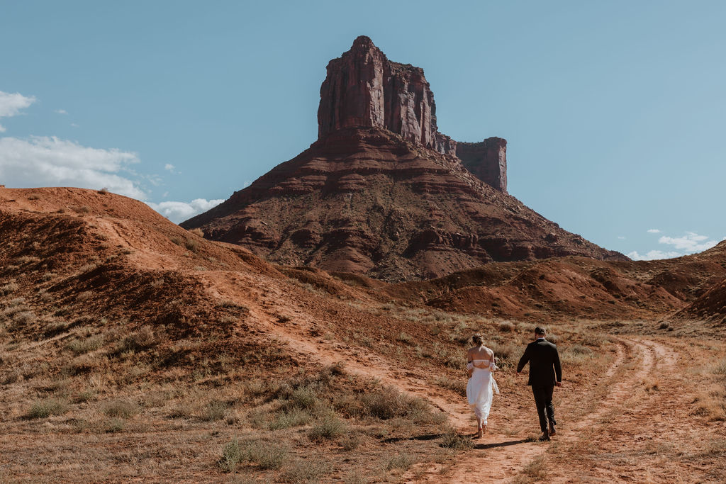 couple walks along path at Moab elopement