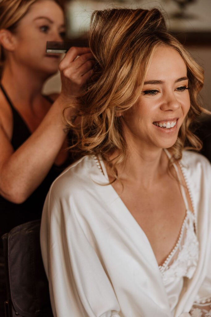 bride has hair done on wedding day