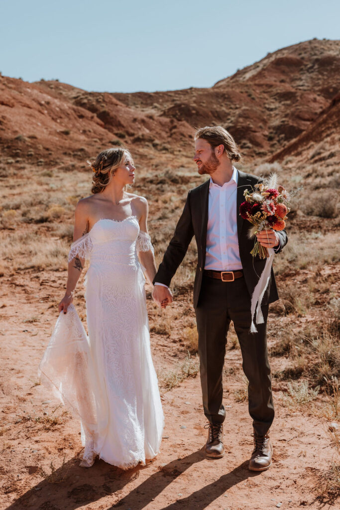 couple holds hands at Moab elopement