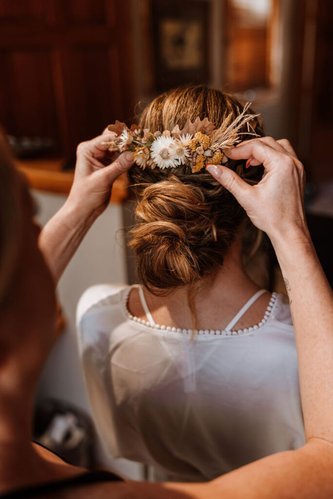 bride has hair done on wedding day