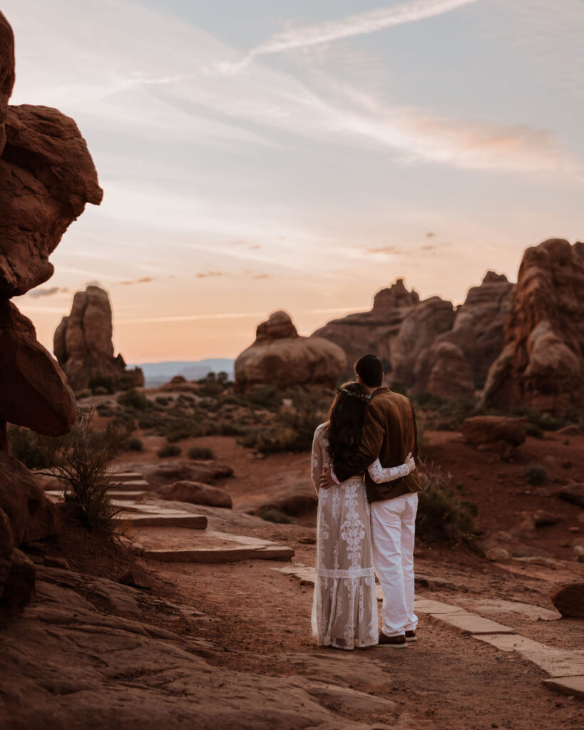 couple embraces at Arches National Park sunset elopement