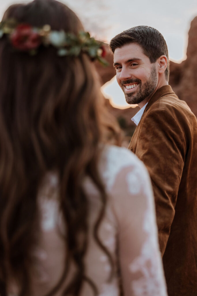 couple walks holding hands at Arches National Park elopement