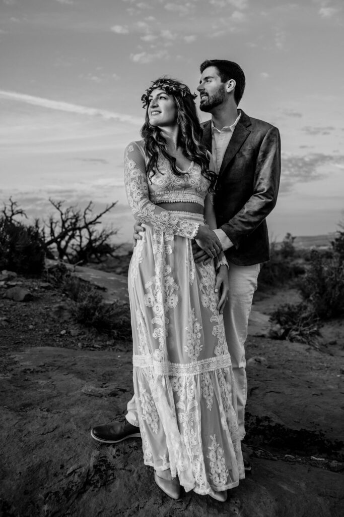 couple embraces at sunset Arches National Park elopement