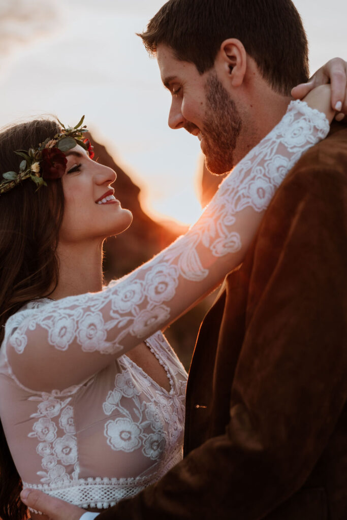 couple embraces at Arches National Park sunset elopement