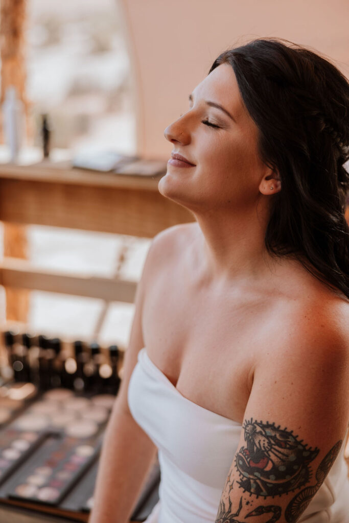 bride has hair and makeup done on wedding day