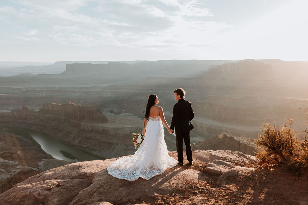 couple stands on edge of cliff at Moab elopement