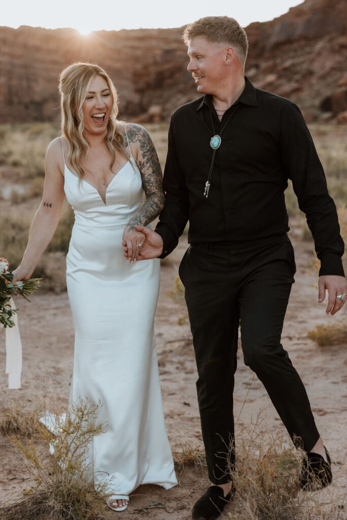 couple holds hands at Moab sunset elopement