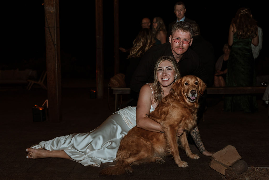 couple pets dog at wedding reception