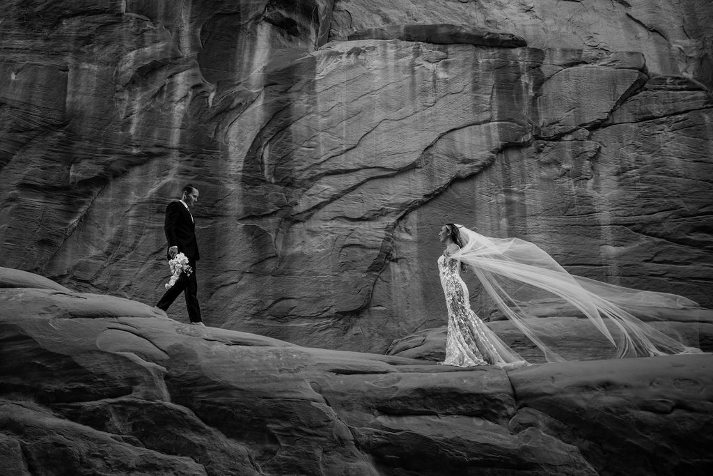 couple walks along Moab red rock