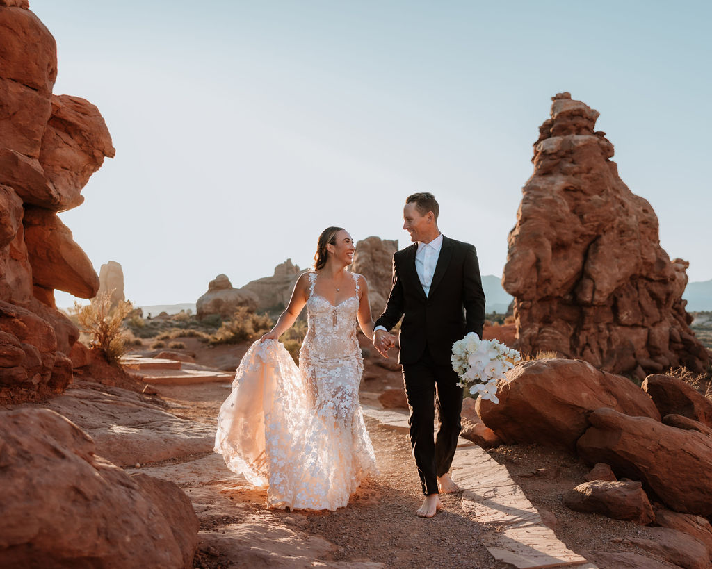 couple walks barefoot at Arches National Park elopement