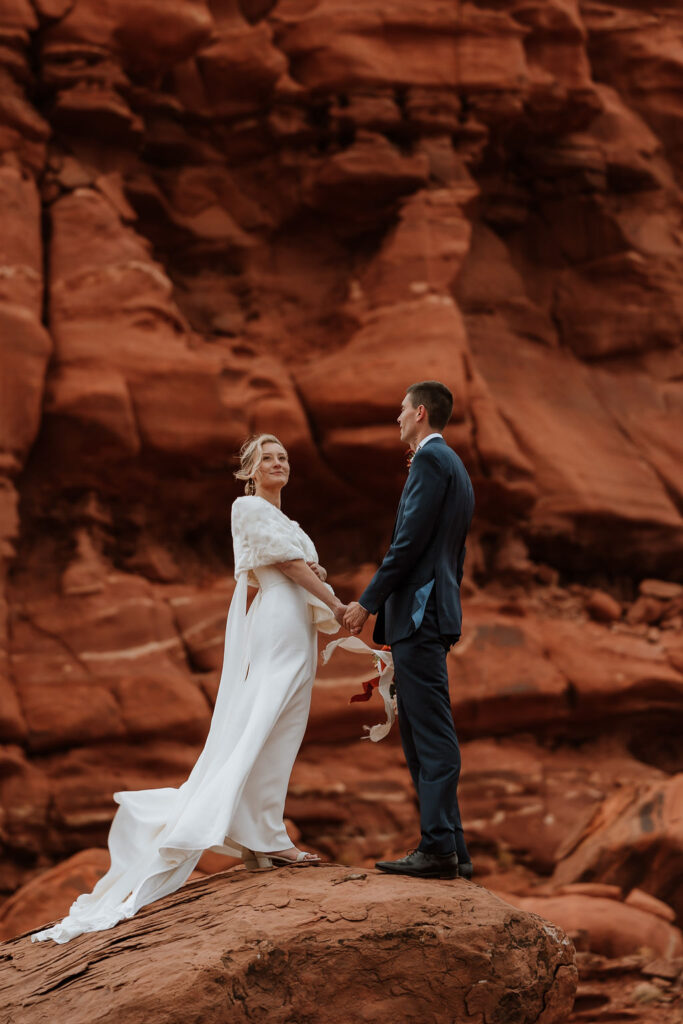 couple stands on rock at red rock Moab elopement 