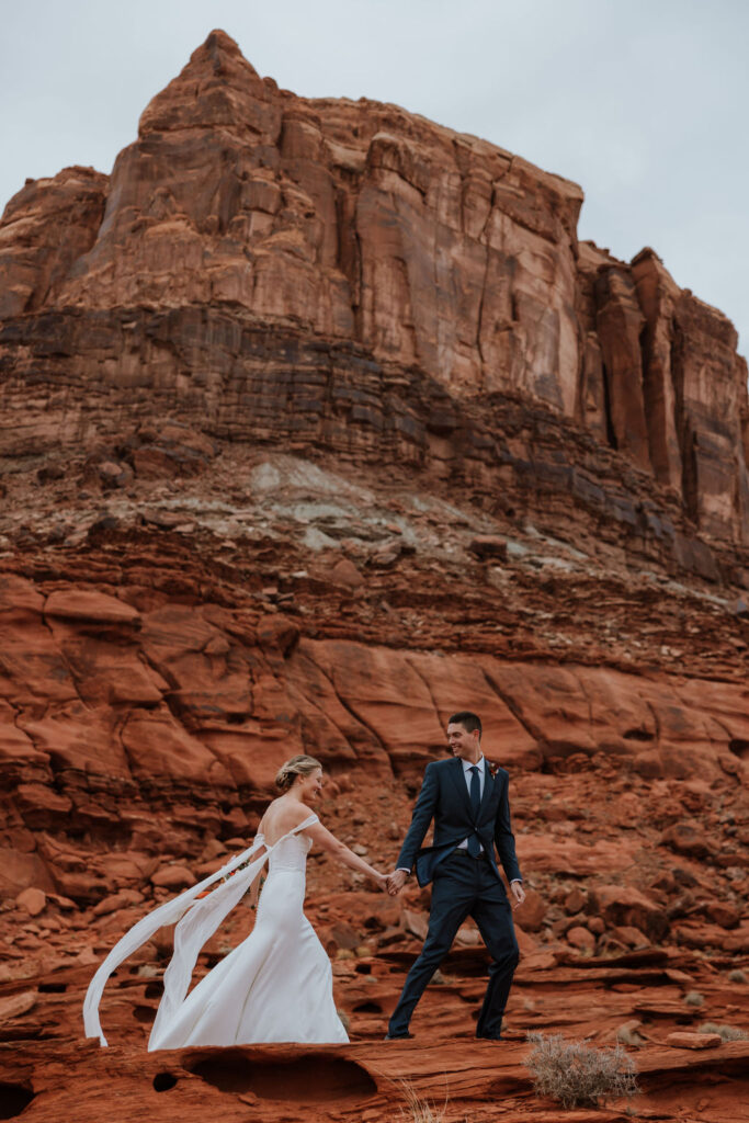 couple walks along red rock Moab elopement 