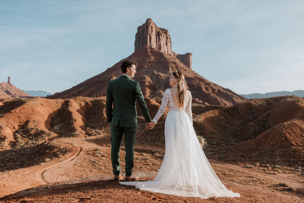 couple holds hands at Moab sunset elopement