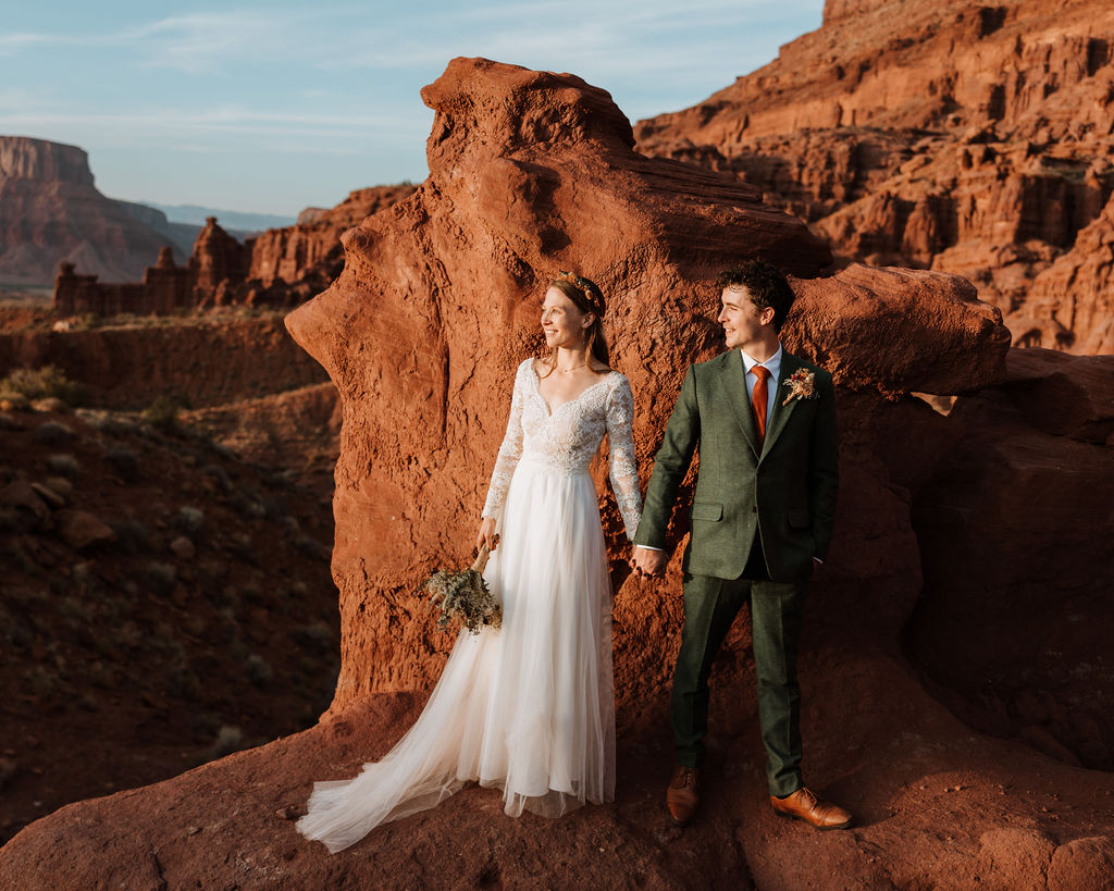 coupe holds hands at Moab overlook