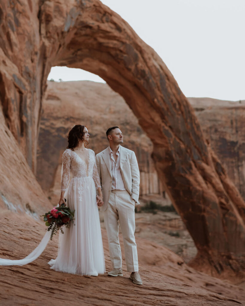 couple elopes at Corona Arch on BLM land in Moab Utah 
