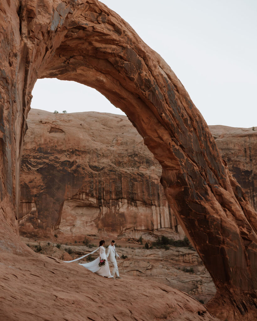 couple elopes at Corona Arch on BLM land in Moab Utah 
