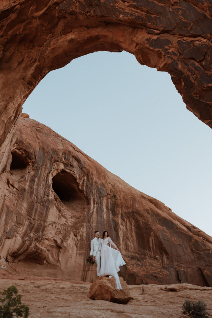 couple stands on rock at Moab elopement