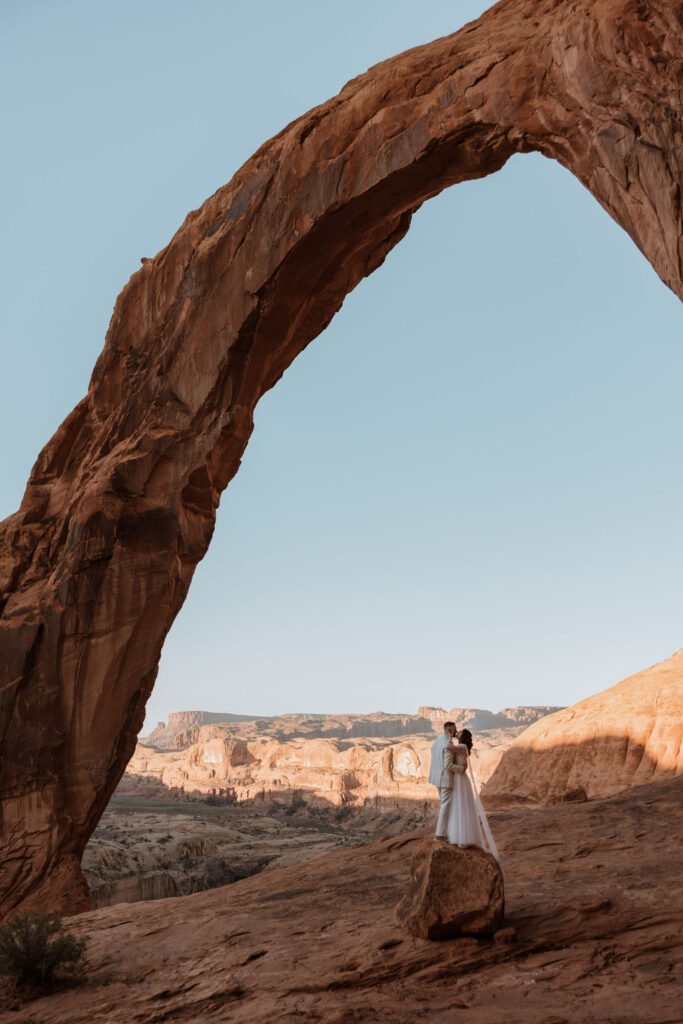 couple stands on rock at Moab elopement