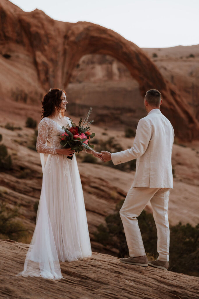 couple holds hands at BLM land Moab Utah elopement