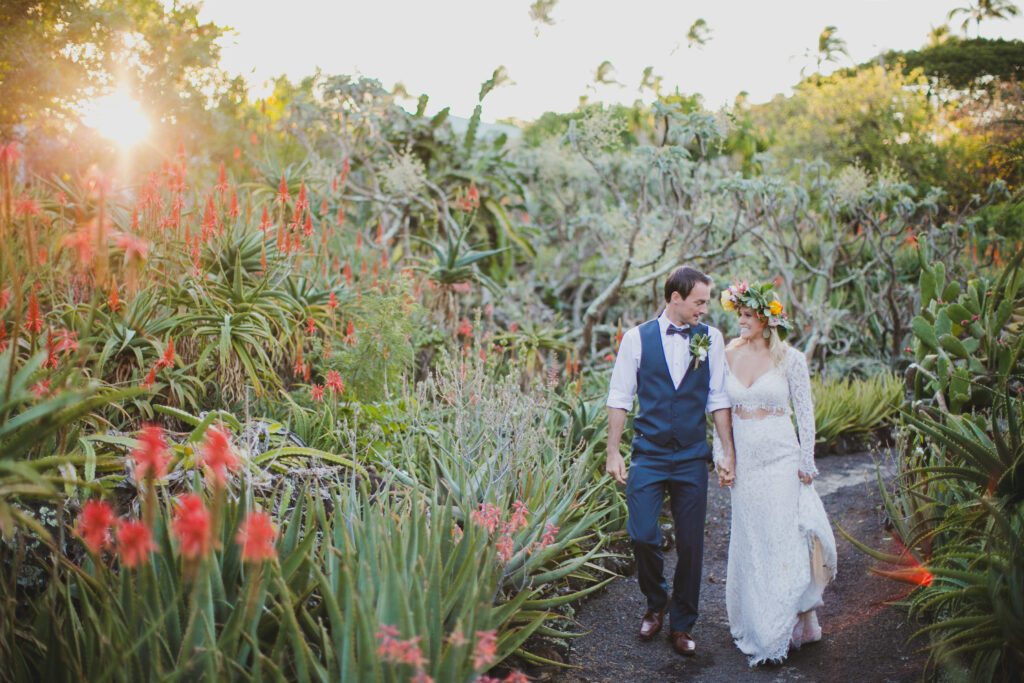 couple walks holding hands at Hawaii wedding