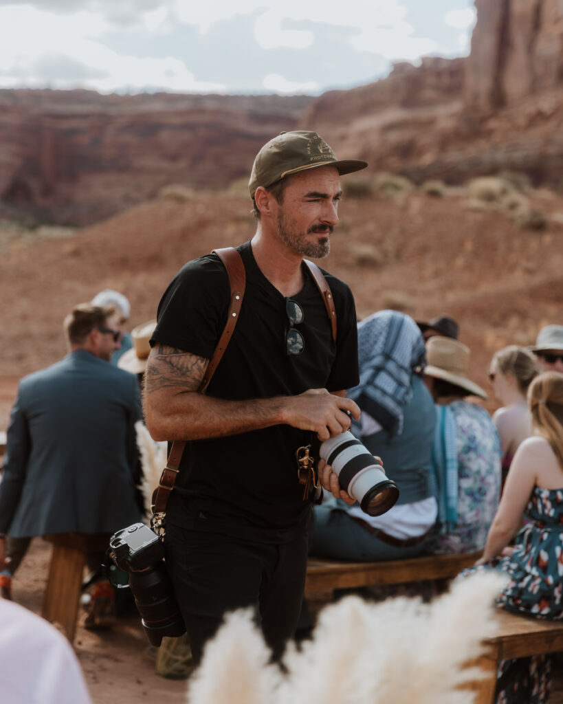 photographer holds camera at Moab desert wedding