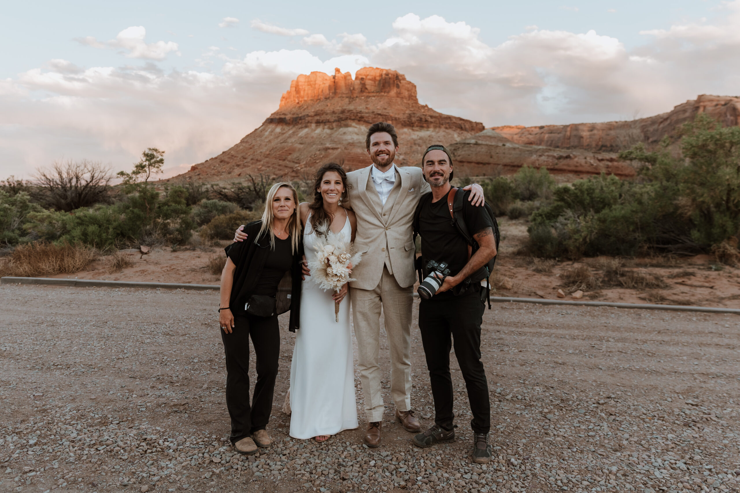 wedding planner and photographer pose with couple