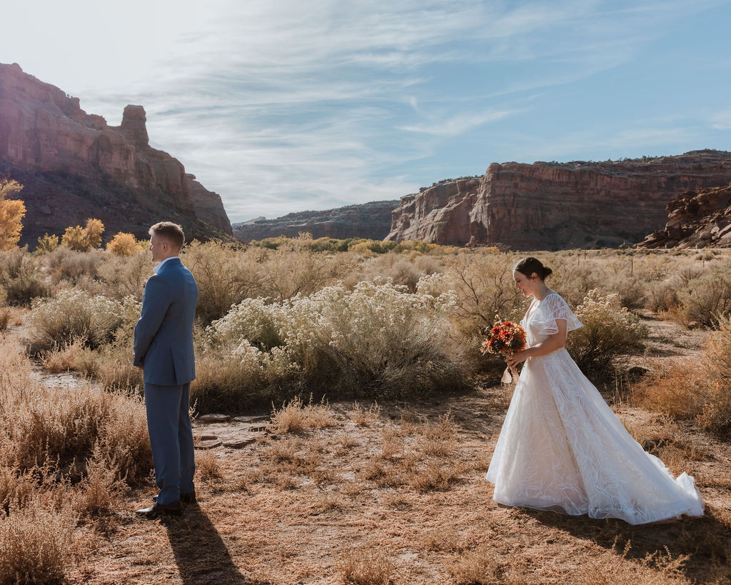 bride approaches groom during Moab elopement first look