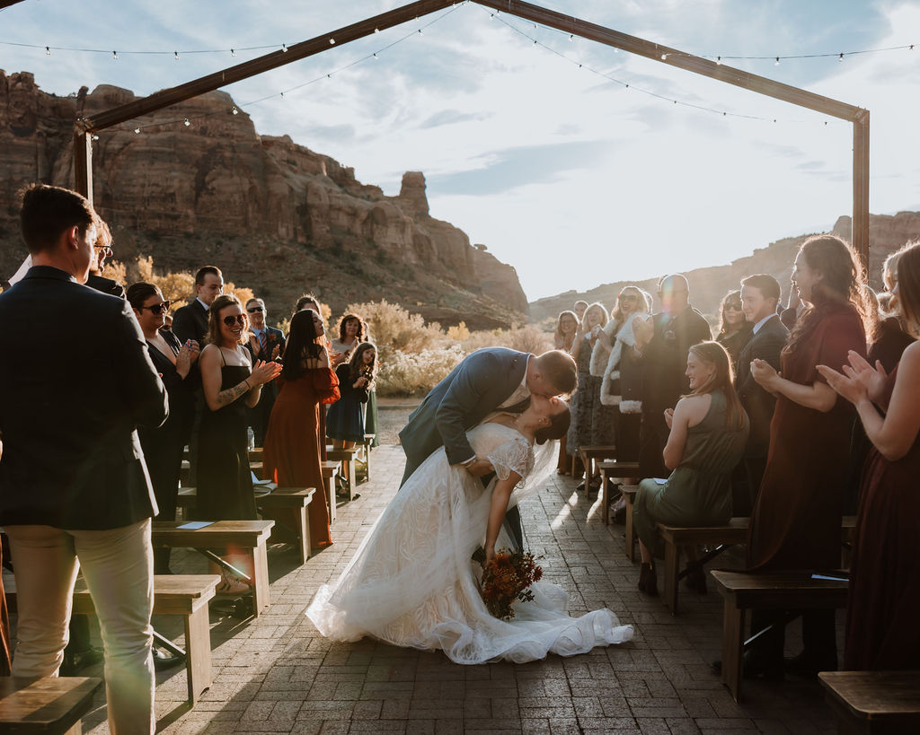 couple kisses during wedding exit