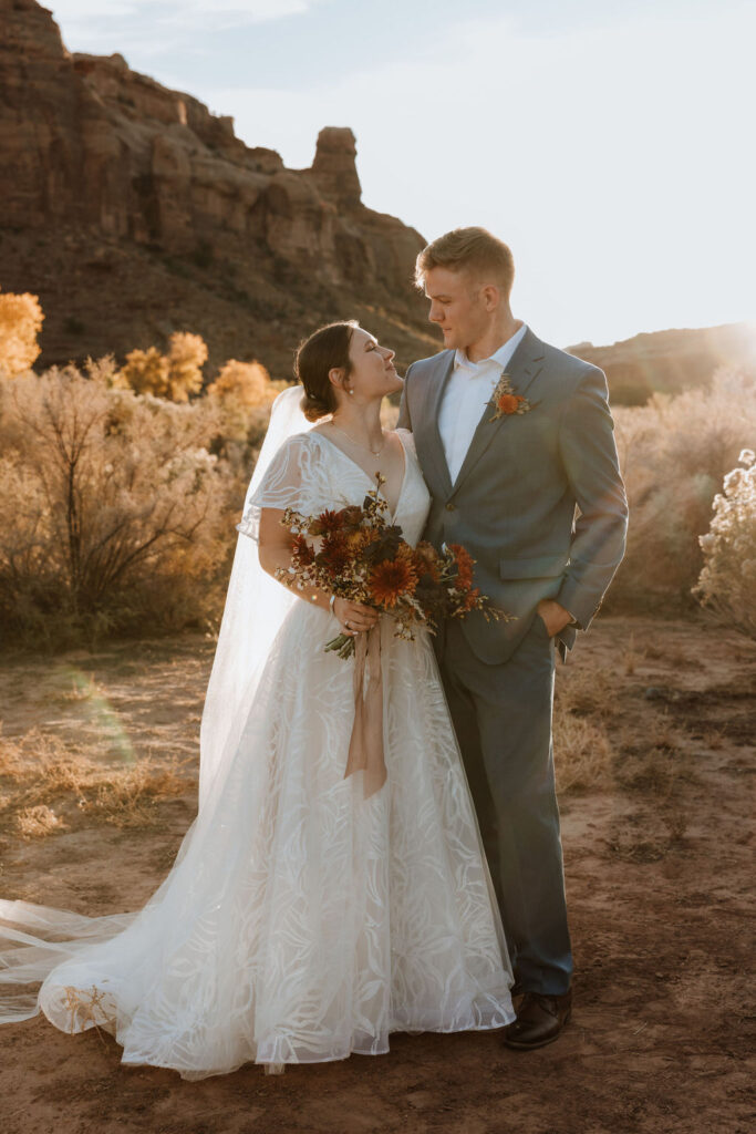 couple embraces at sunset Moab elopement