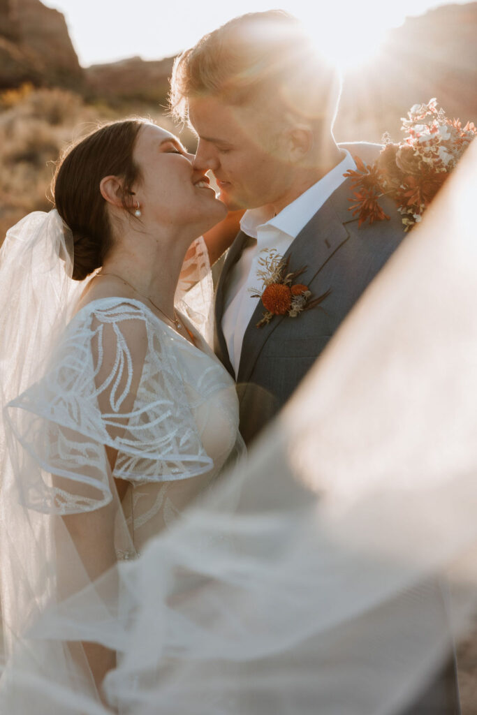 couple kisses at sunset Moab elopement