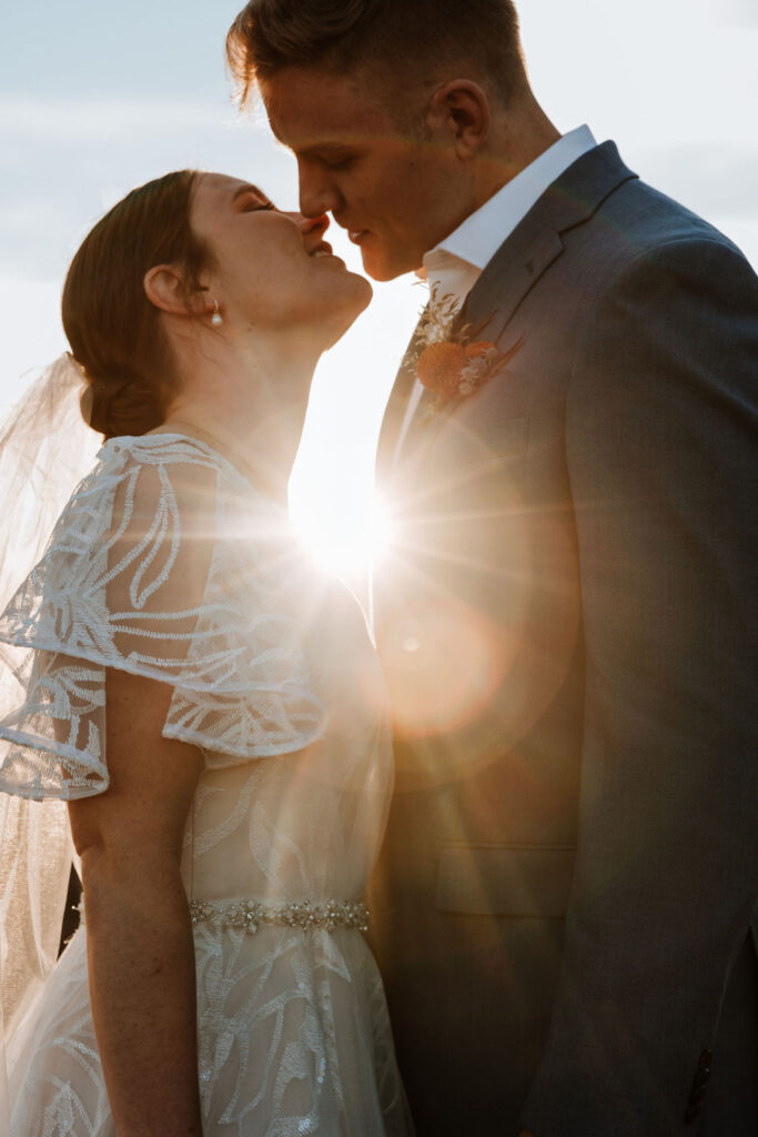 couple kisses at sunset Moab elopement