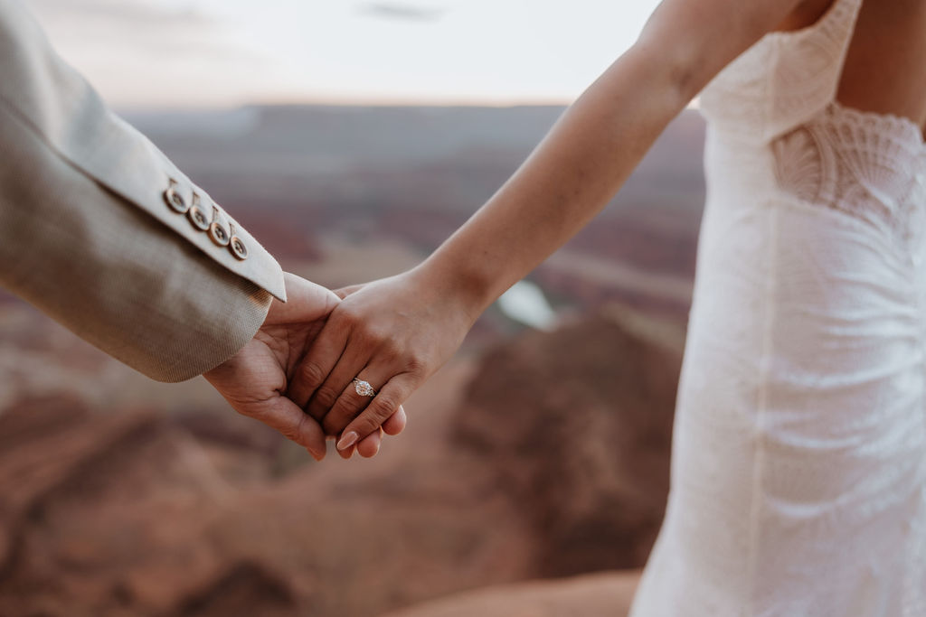 couple holds hands with wedding ring