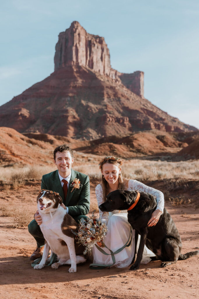 couple poses with dogs at Castle Valley Moab elopement