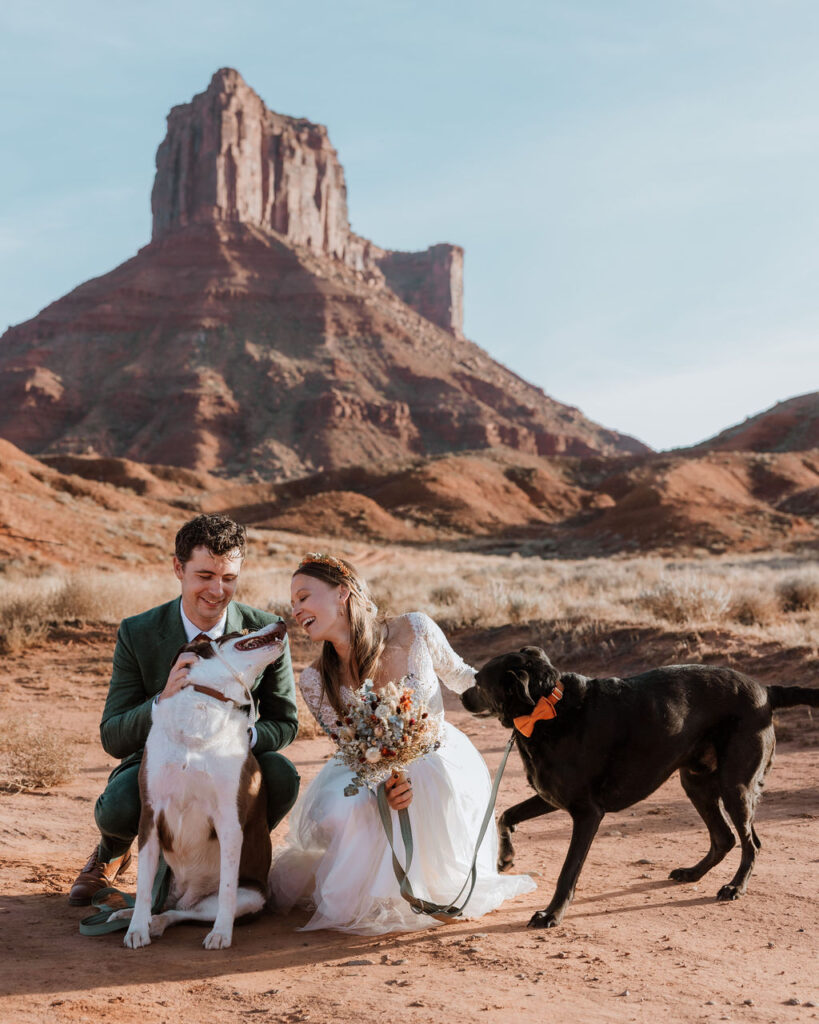 couple poses with dogs at Castle Valley Moab elopement