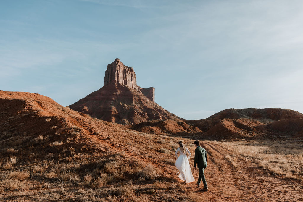 couple walks along path at Castle Valley Moab elopement