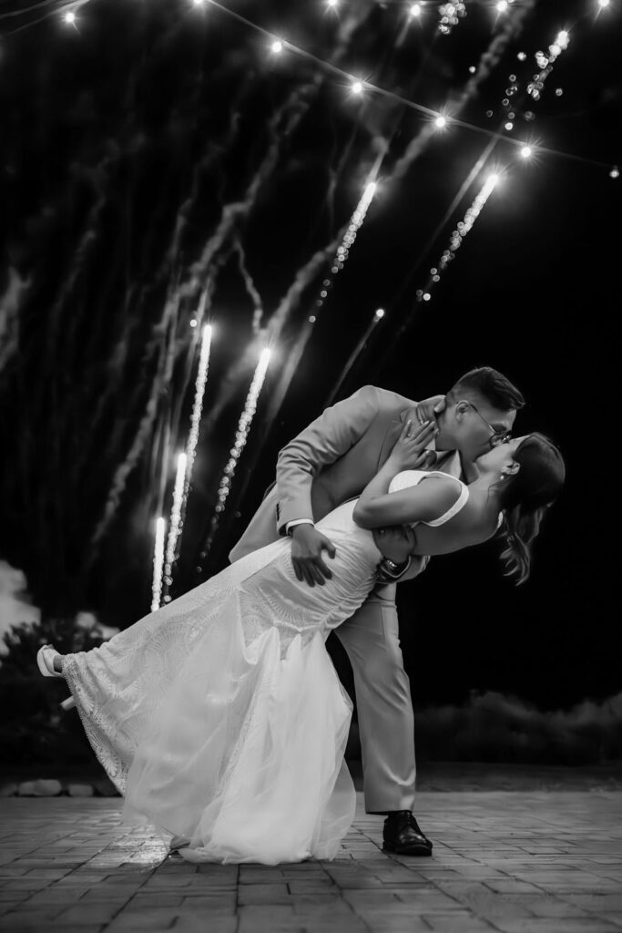 couple kisses under wedding fireworks