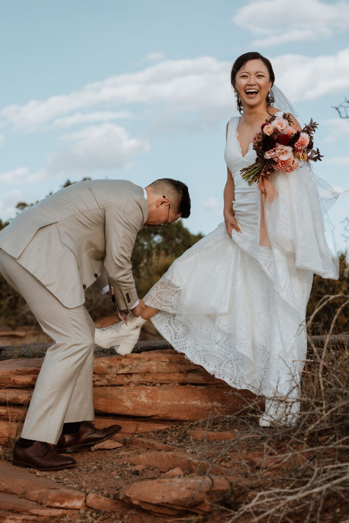 groom ties bride's shoe at Dead Horse Point elopement