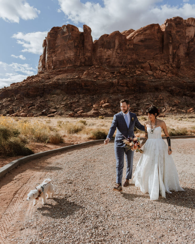 couple walks dog at Moab elopement