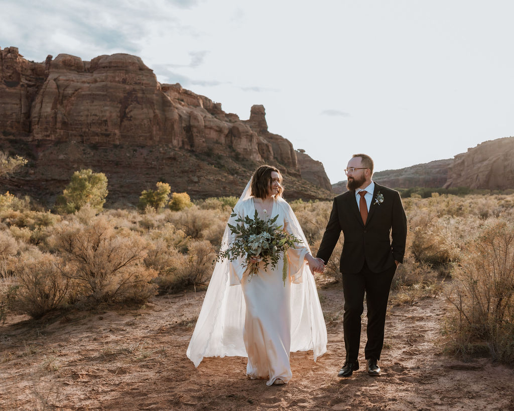 couple walks along Moab desert at The Red Earth Venue