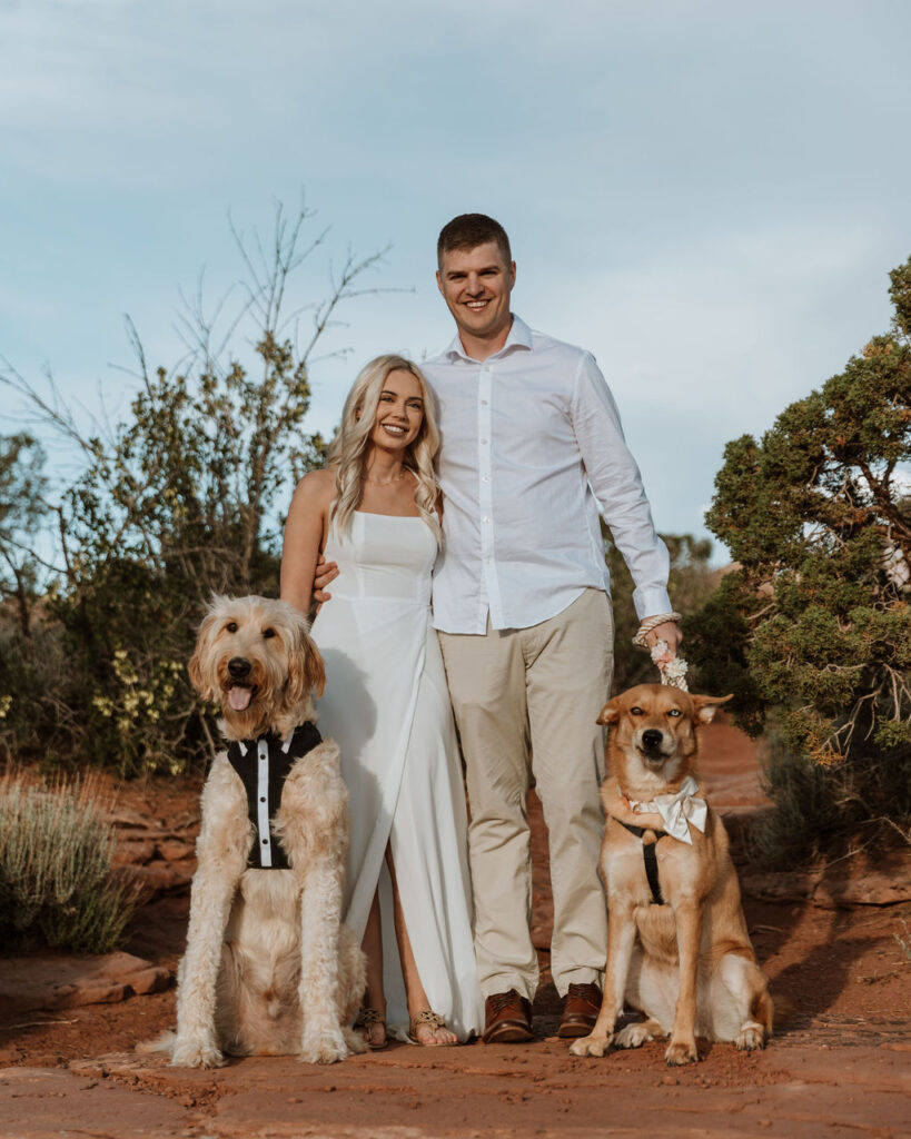 couple poses with dogs at Moab elopement