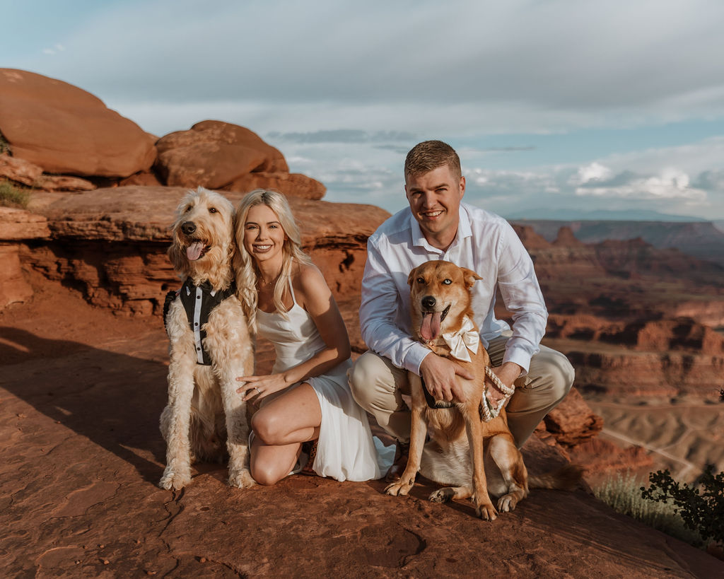 couple poses with dogs at Moab elopement